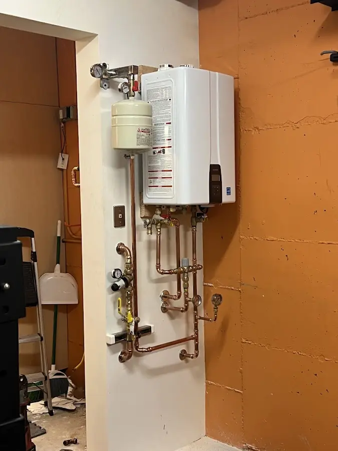 Plumbing technician inspecting water heater connections in Eustis